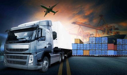 Shipping containers at a harbor with truck and air plane in the air